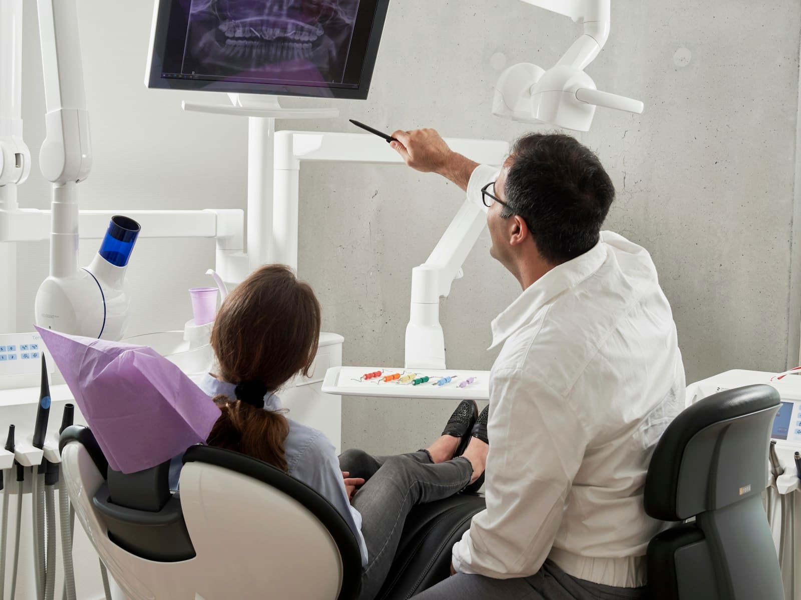 Dentist reviewing a digital scan with a patient in a bright treatment room